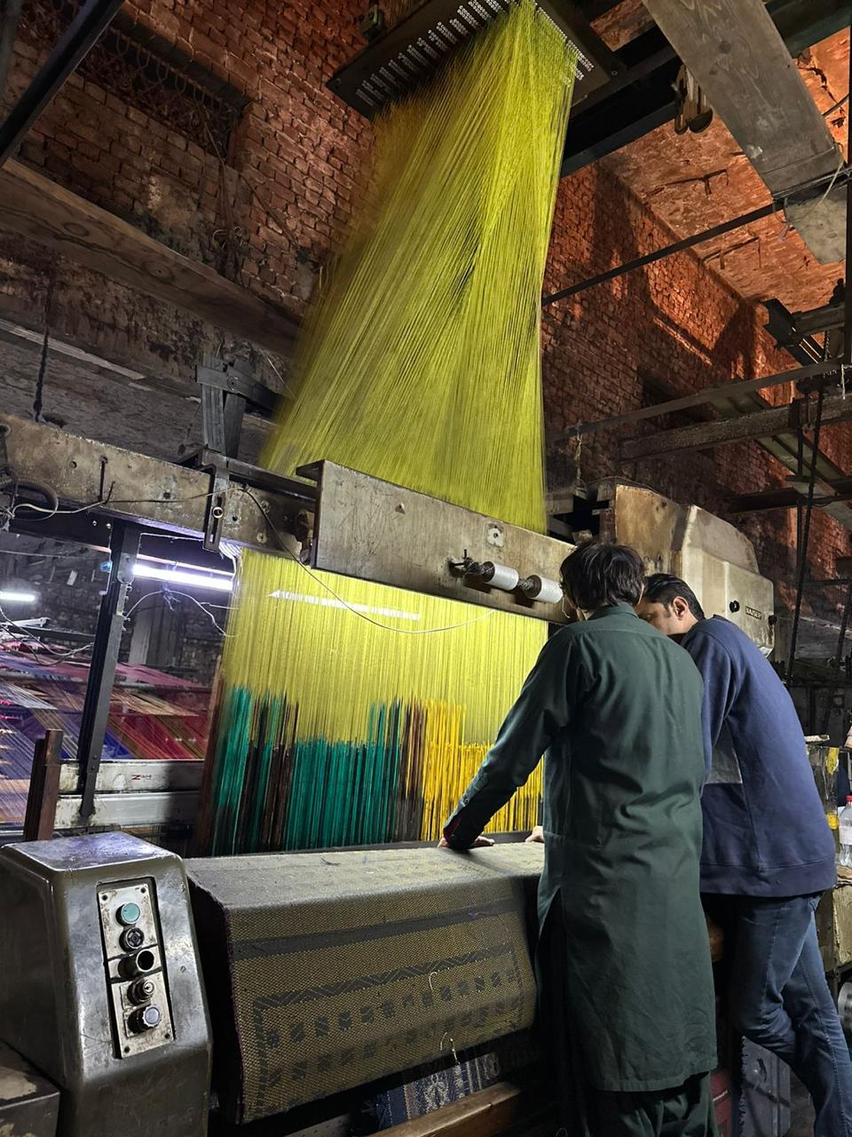 Workers operating the weaving loom at AMTI factory